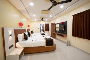 a bedroom with a large bed and a television at RMA Joliday Inn in Pondicherry