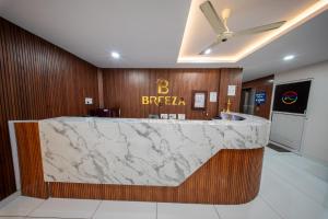 a lobby with a marble counter with a brazil sign at BREEZA GRANd in Kazhakuttam