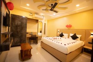 a bedroom with a bed and a desk in a room at RMA Joliday Inn in Pondicherry +59 photos