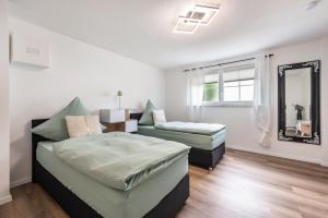 a bedroom with two beds and a mirror at Ferienwohnung Marina in Stockach