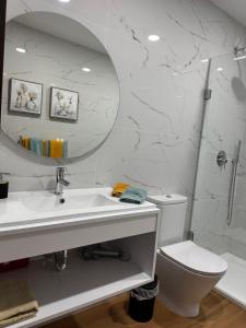a bathroom with a sink and a toilet and a mirror at RR Suites in São Mateus