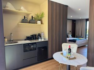 a kitchen with a table and a room with a bed at RR Suites in São Mateus