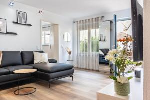 a living room with a black leather couch at Ferienwohnung Marina in Stockach