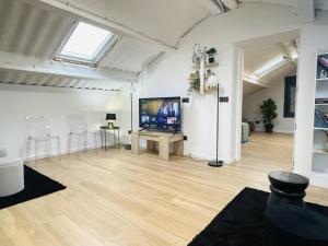 a living room with a tv and a wooden floor at Villa 1-12 Personas a 3 minutos de las playas in Villanueva de Arosa