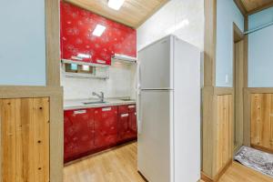 a white refrigerator in a kitchen with red cabinets at Suncheonman Muhan Dojan Pension in Suncheon +57 photos