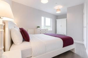 a white bedroom with a white bed and a window at Roomspace Serviced Apartments - Vertex House in Croydon