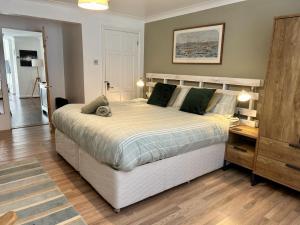 a bedroom with a large bed and a wooden floor at Garden Apartment by the Pier in Portsmouth