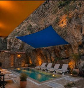 a pool with chairs and a rock wall at The Little Prince Boutique Otel in Antalya