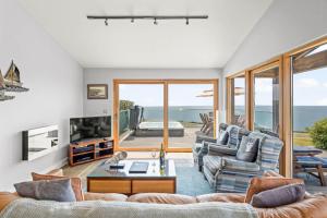 a living room with two couches and a television at House 38 in Looe