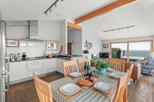 a kitchen and dining room with a table and chairs at House 38 in Looe