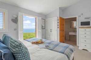 a bedroom with a bed with a tray of fruit on it at House 38 in Looe +28 photos