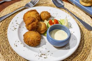 a plate of food with meatballs and a dipping sauce at Chundu Island in Victoria Falls