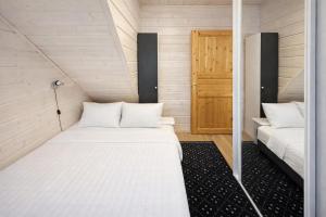 a small room with two beds and a door at Northern Lights Lodge in Kittilä