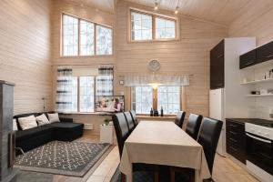 a kitchen and living room with a table and a couch at Northern Lights Lodge in Kittilä