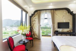 a bedroom with a bed and a balcony with a television at PG indochine Mộc Châu in Sơn La