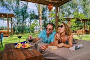 a man and woman sitting at a table with glasses of wine at Hoianbang Beach Front Villa and Restaurant in An Bàn (2)