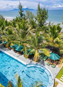 an overhead view of a swimming pool with palm trees and the ocean at Hoianbang Beach Front Villa and Restaurant in An Bàn (2)