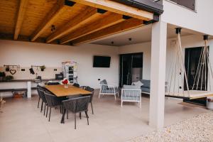 a dining room and living room with a table and chairs at Novak Home - Luxury villa with indoor pool & sauna in Štrigova