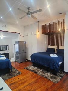 a bedroom with two beds and a ceiling fan at Ludiz Self Catering Guest House in Avondale +75 photos