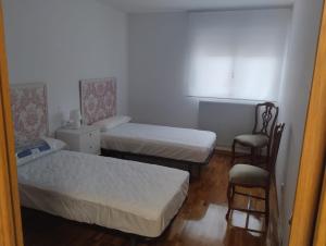 a small room with two beds and a chair at Eclipse in Olvega