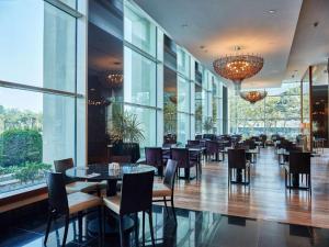 a restaurant with tables and chairs and windows at HILTON Residence of LUXURY 5 STARS apartment F1 in Baku