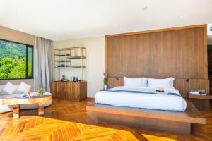 a bedroom with a large bed and a wooden wall at Z Exquisite Koh Samui Domain with Infinity Pool in Nathon Bay +23 photos