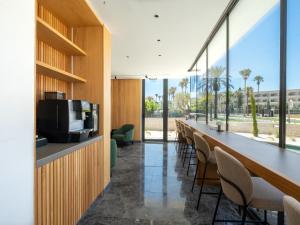 a long bar in a room with chairs and a television at Poseidon by Deserve in Paphos
