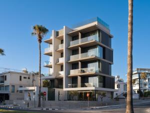 a building with palm trees in front of it at Poseidon by Deserve in Paphos