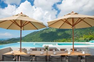 a restaurant with tables and umbrellas and a pool at Z Exquisite Koh Samui Domain with Infinity Pool in Nathon Bay