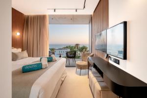 a hotel room with a large television and a couch at Poseidon by Deserve in Paphos