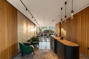 a lobby with green chairs and a long bar at Poseidon by Deserve in Paphos +23 photos