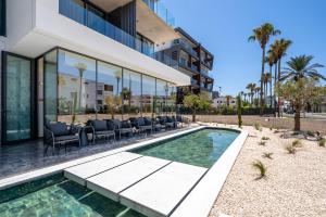 a house with a swimming pool in front of a building at Poseidon by Deserve in Paphos