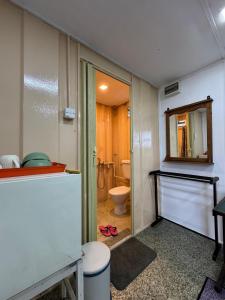a bathroom with a toilet and a mirror at Beach hut cabin in Marang