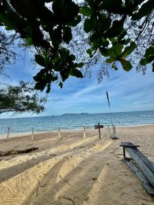 a bench on the beach with the ocean in the background at Beach hut cabin in Marang