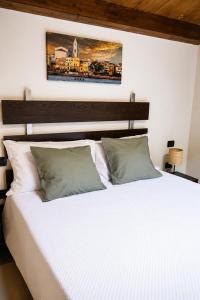 a bedroom with a white bed with a wooden headboard at Istmo Room and Breakfast in Lesina