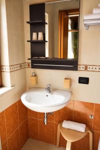 a bathroom with a sink and a mirror and a stool at Istmo Room and Breakfast in Lesina