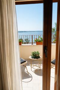 a room with a view of the ocean from a balcony at Istmo Room and Breakfast in Lesina