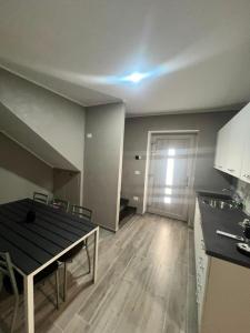 an empty room with a table and a kitchen with a door at Affittacamere Plaza in Pietracatella
