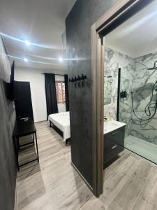 a bathroom with a shower and a sink and a bed at Affittacamere Plaza in Pietracatella +8 photos
