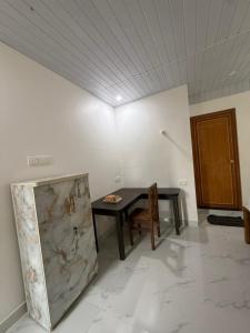 a dining room with a table and a wooden door at Tangerine House in Canacona