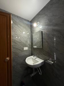 a bathroom with a sink and a mirror at Tangerine House in Canacona