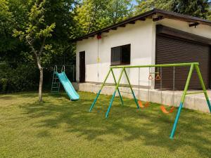 two swings in a yard next to a house at Villa Yarema Mountain Relax with Hot Jacuzzi & Sauna by BookVillaBG in Zheleznitsa