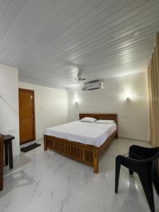 a bedroom with a bed and a desk and a chair at Tangerine House in Canacona