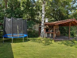 a house with a trampoline in the yard at Villa Yarema Mountain Relax with Hot Jacuzzi & Sauna by BookVillaBG in Zheleznitsa