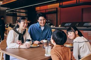 a group of people sitting at a table eating food at FAV LUX Asahikawa in Asahikawa