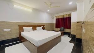 a bedroom with a bed and a television in it at Tirupati Stays in Tirupati