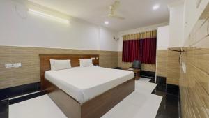 a bedroom with a bed and a television in it at Tirupati Stays in Tirupati +1 photo