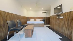 a hotel room with a bed and a tv at Tirupati Stays in Tirupati