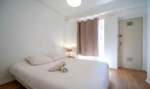 a teddy bear sitting on a bed in a bedroom at Studio cosy - proche cathédrale in Chalon-sur-Saône