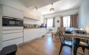 a kitchen with white cabinets and a table with chairs at Studio cosy - proche cathédrale in Chalon-sur-Saône